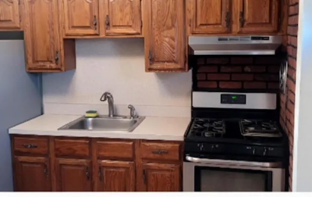 a kitchen with granite countertop a stove sink and cabinets