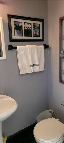 a white toilet sitting next to a white wall