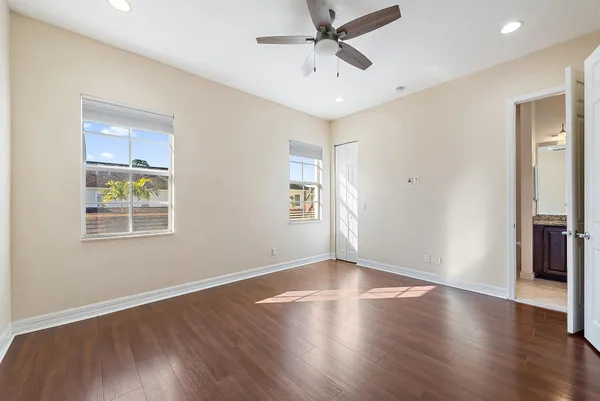 a view of an empty room with a window and wooden floor