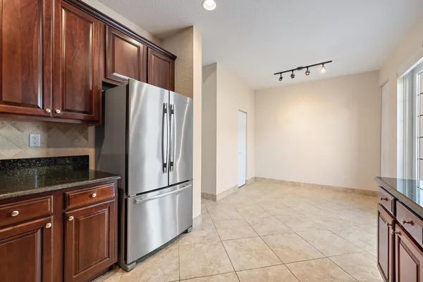 a kitchen with stainless steel appliances granite countertop a refrigerator and a sink