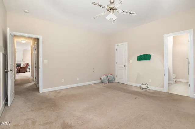 a view of an empty room with wooden floor and windows