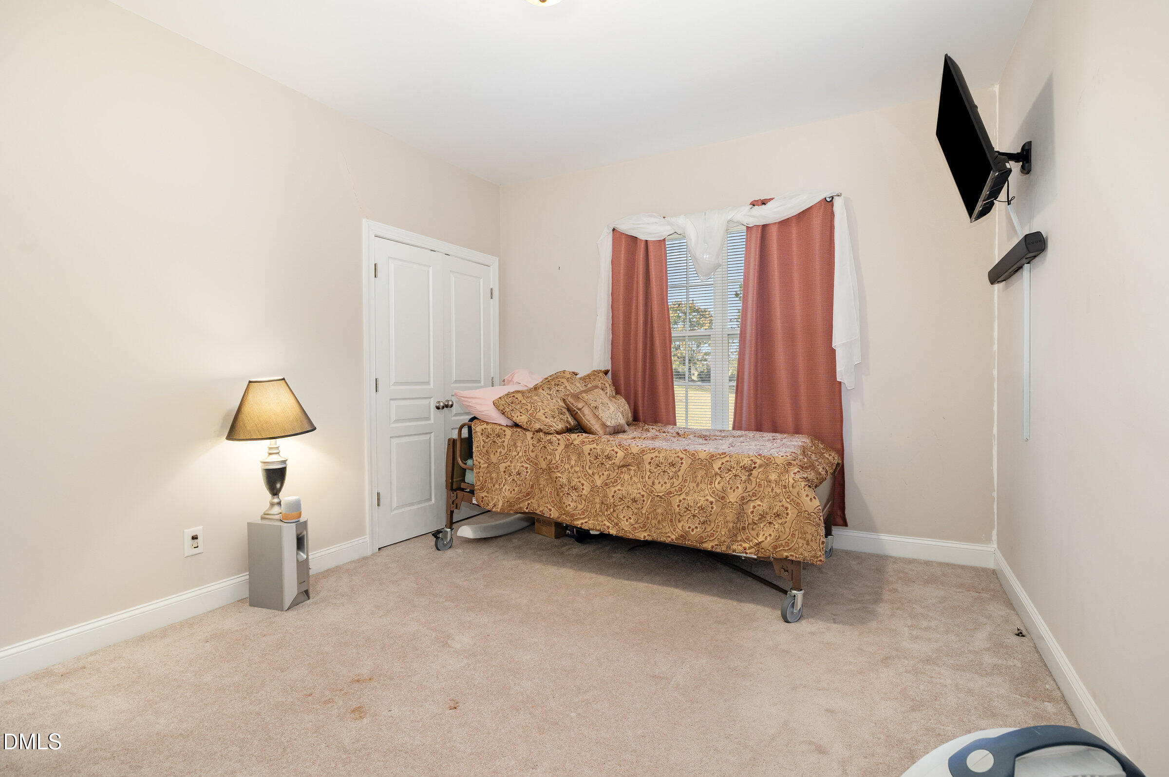 7300 Singlepond Lane Willow Spring, NC 27592 - Photo 18 of 34 a bedroom with a bed and a flat tv screen on a dresser