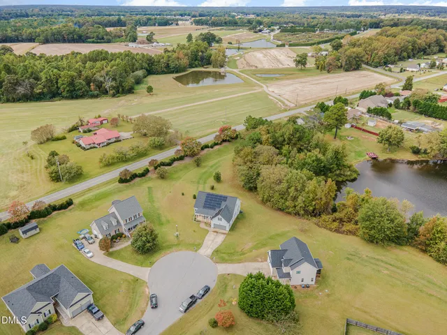 an aerial view of residential houses with outdoor space and river