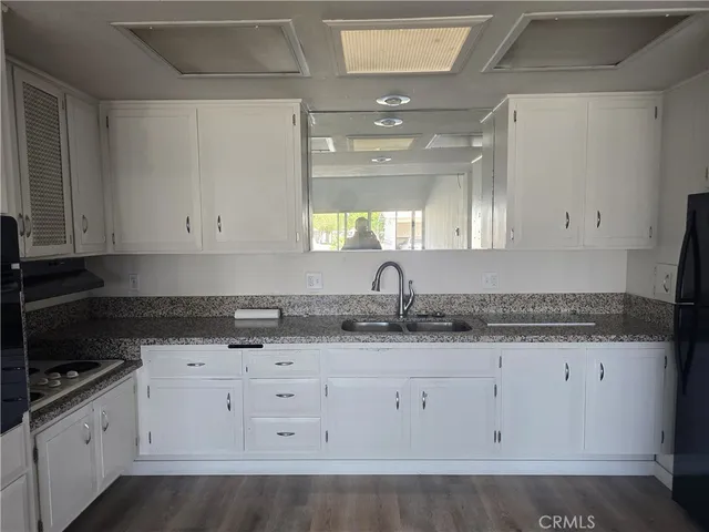 a kitchen with granite countertop white cabinets and a stove