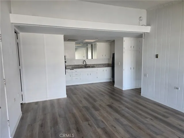 a view of a kitchen cabinets a sink and wooden floor