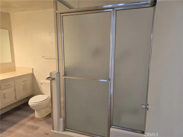 a bathroom with a granite countertop shower and a toilet