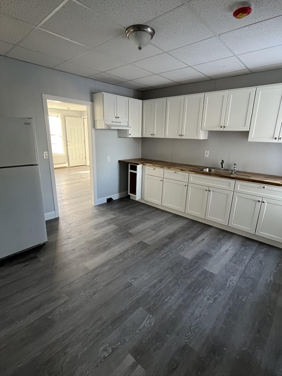 106 Kilburn Street, Unit 2S Fall River, MA 02724 - Photo 2 of 5 a large kitchen with cabinets wooden floor and stainless steel appliances