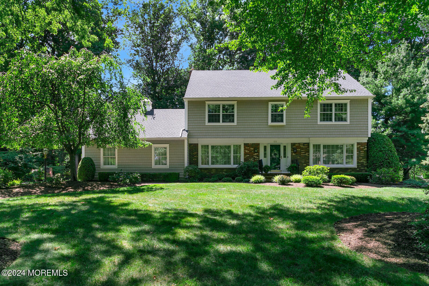 a aerial view of a house next to a big yard and large trees