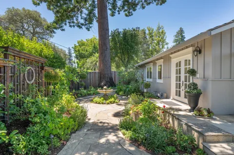 a view of a patio with couches and a table and chairs with wooden fence