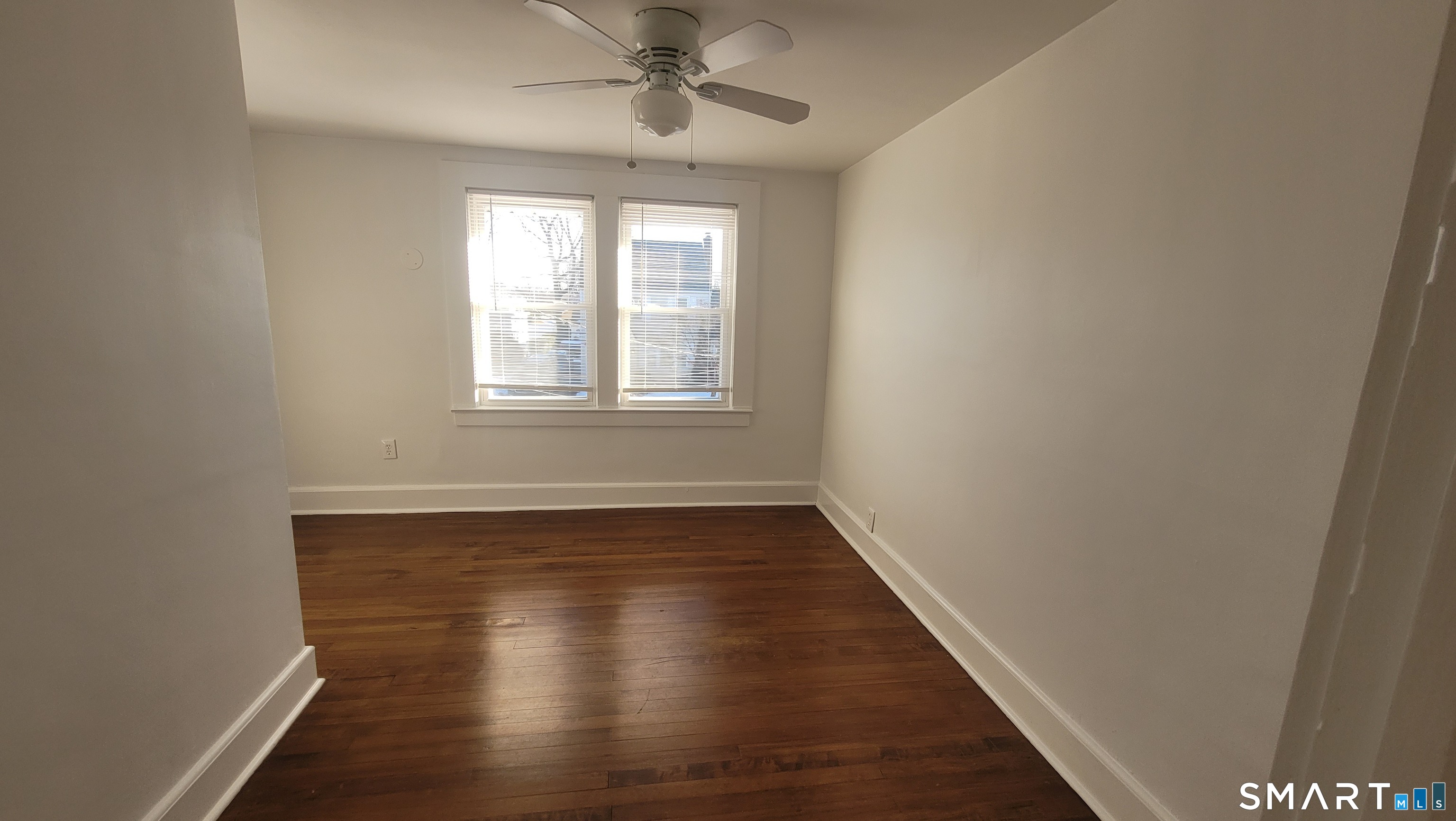 10 Olmstead Place Norwalk, CT 06855 - Photo 15 of 18 an empty room with wooden floor chandelier fan and windows