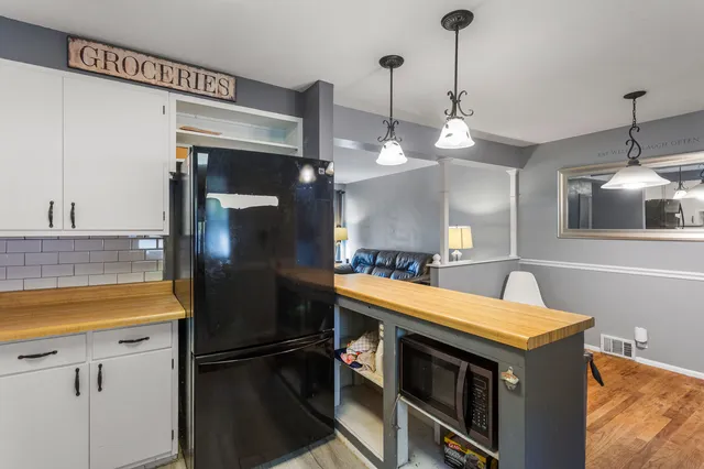 a kitchen with stainless steel appliances granite countertop a refrigerator a sink and a stove