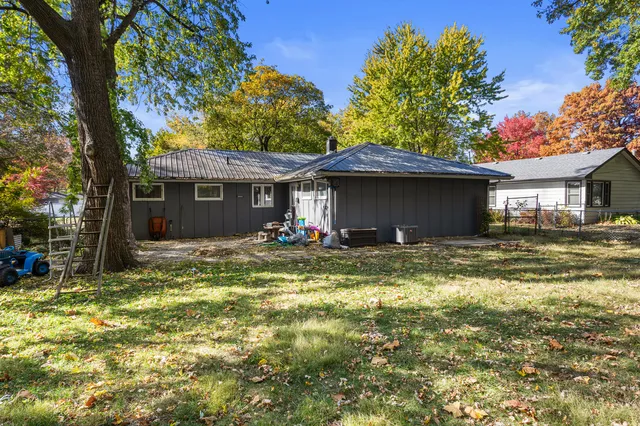 a view of a house with pool and chairs next to a yard