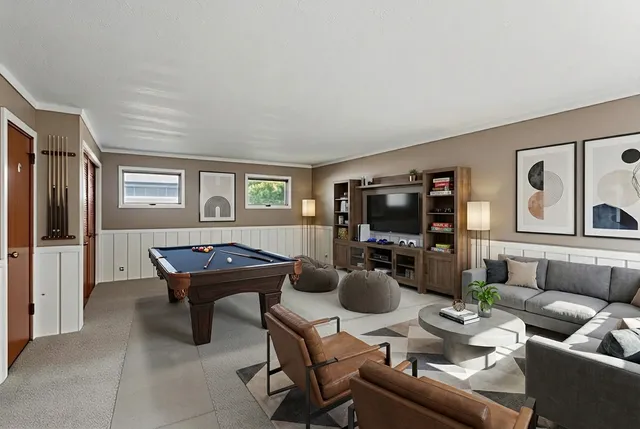 a living room with furniture a flat screen tv and kitchen view