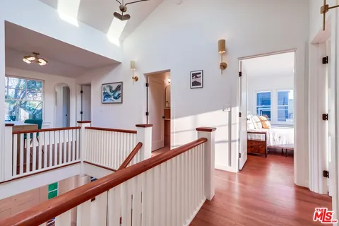 a bedroom with a large bed and a flat tv screen on dresser