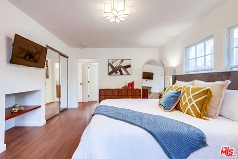 a bedroom with a bed and a potted plant