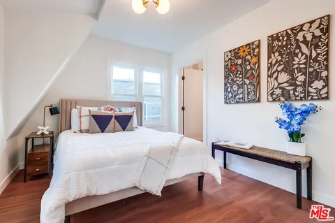 a bedroom with a bed and wooden floor