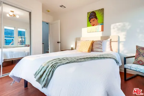 a view of staircase with lots of frames on wall and wooden floors