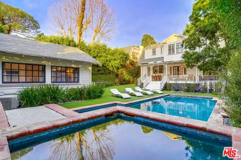 a living room with furniture a flat screen tv and a floor to ceiling window