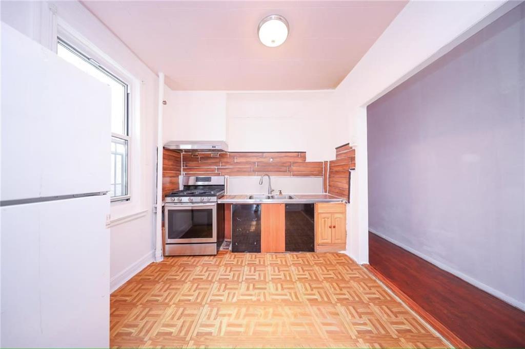 3617 Quentin Road Brooklyn, NY 11234 - Photo 12 of 16 a large kitchen with a stove and a refrigerator