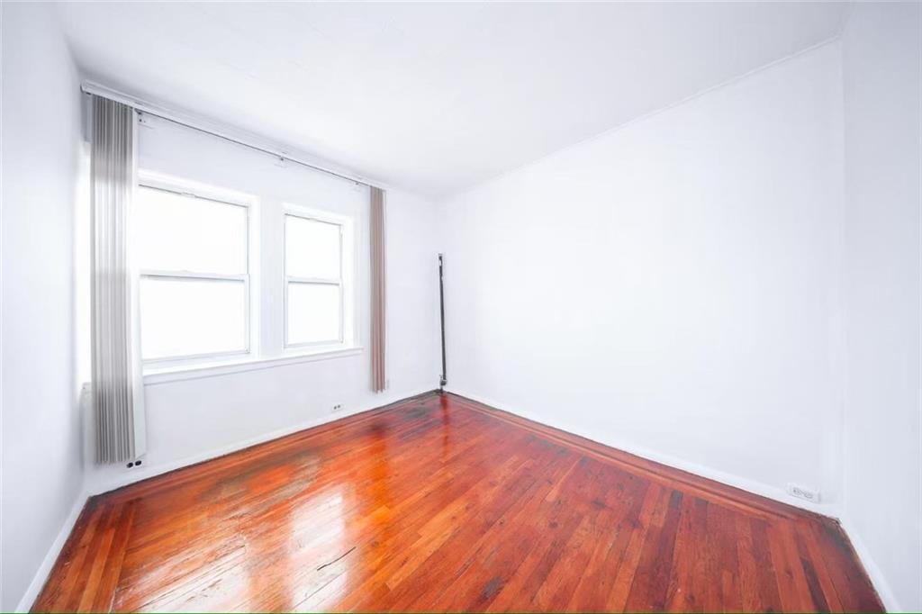 3617 Quentin Road Brooklyn, NY 11234 - Photo 9 of 16 an empty room with wooden floor and windows