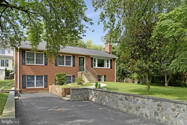 a front view of a house with a garden and tree