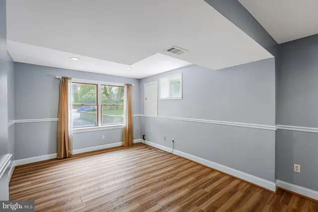 a view of a room with wooden floor and white walls