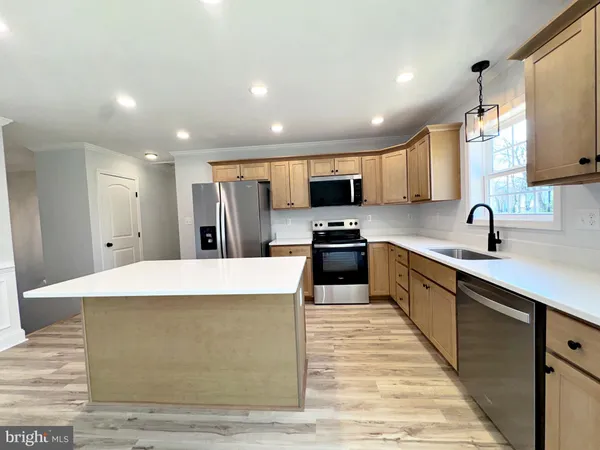 a large kitchen with stainless steel appliances lots of counter space and wooden floor