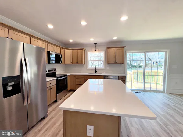 a kitchen with granite countertop a refrigerator and a stove top oven
