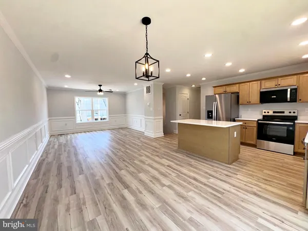 a open kitchen with kitchen island a refrigerator stove and oven with wooden floor