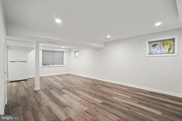 a view of empty room with wooden floor and window