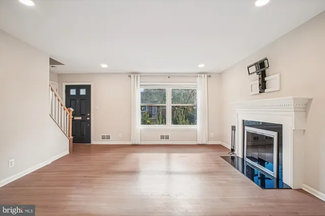 a view of an empty room with a fireplace and a window