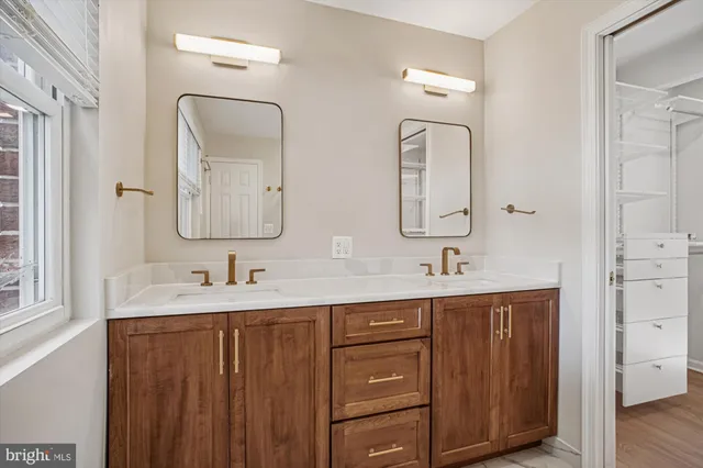 a bathroom with double vanity sinks and a mirror
