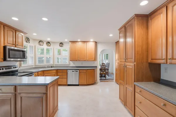 a kitchen with stainless steel appliances granite countertop a refrigerator a sink dishwasher and a stove