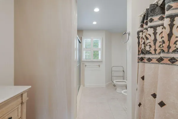a bathroom with a granite countertop sink a toilet and shower