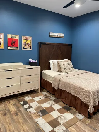 a bedroom with a bed and a lamp on dresser