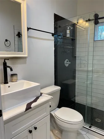 a bathroom with a shower toilet and sink