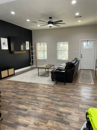 a living room with furniture and a wooden floor