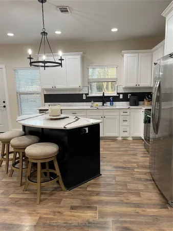 a kitchen with stainless steel appliances granite countertop a table chairs stove a refrigerator and cabinets