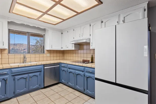 a kitchen with stainless steel appliances granite countertop a refrigerator and a sink