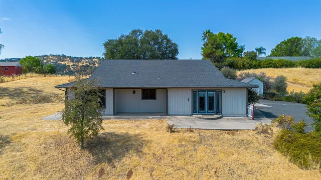 a front view of house with yard and trees in the background