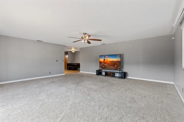 an empty room with windows and flat screen tv