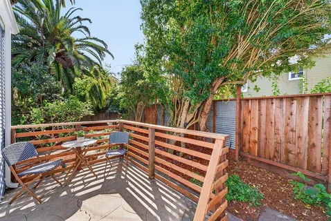 a view of a yard with plants and wooden fence
