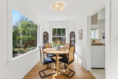 a dining room with furniture a window and wooden floor