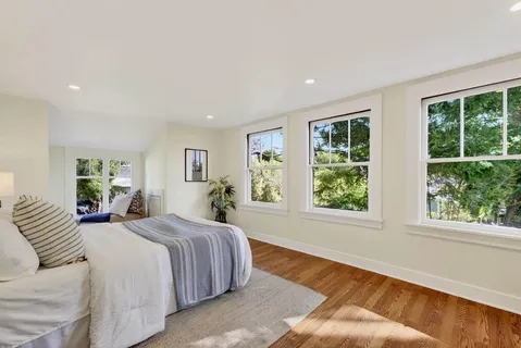a bedroom with a large bed and windows