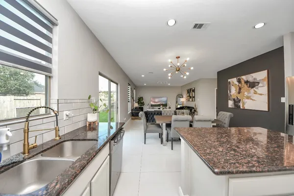 a view of kitchen island a sink dining table and chairs