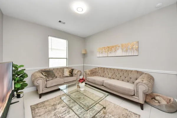 a living room with a couch and a potted plant