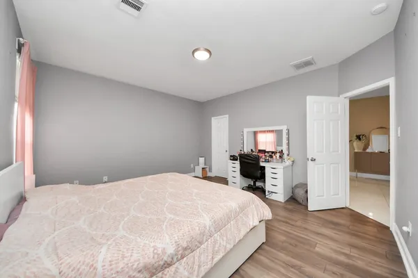 a bedroom with a bed and a flat tv screen on the dresser