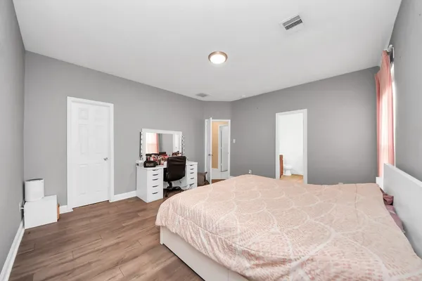 a large bedroom with a bed and a large window