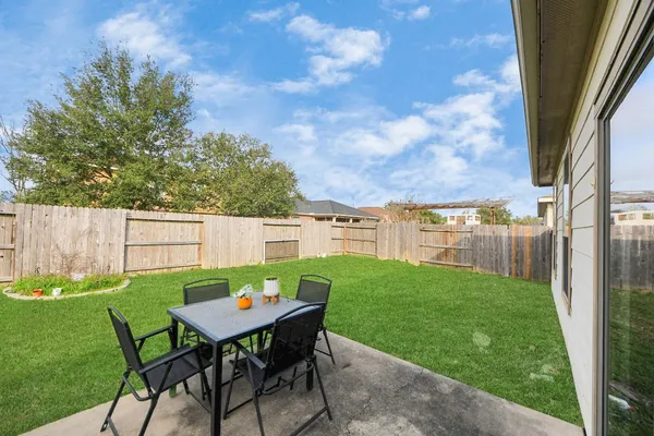 a backyard of a house with table and chairs