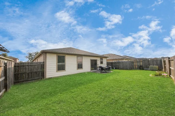 a white house with a big yard and large trees
